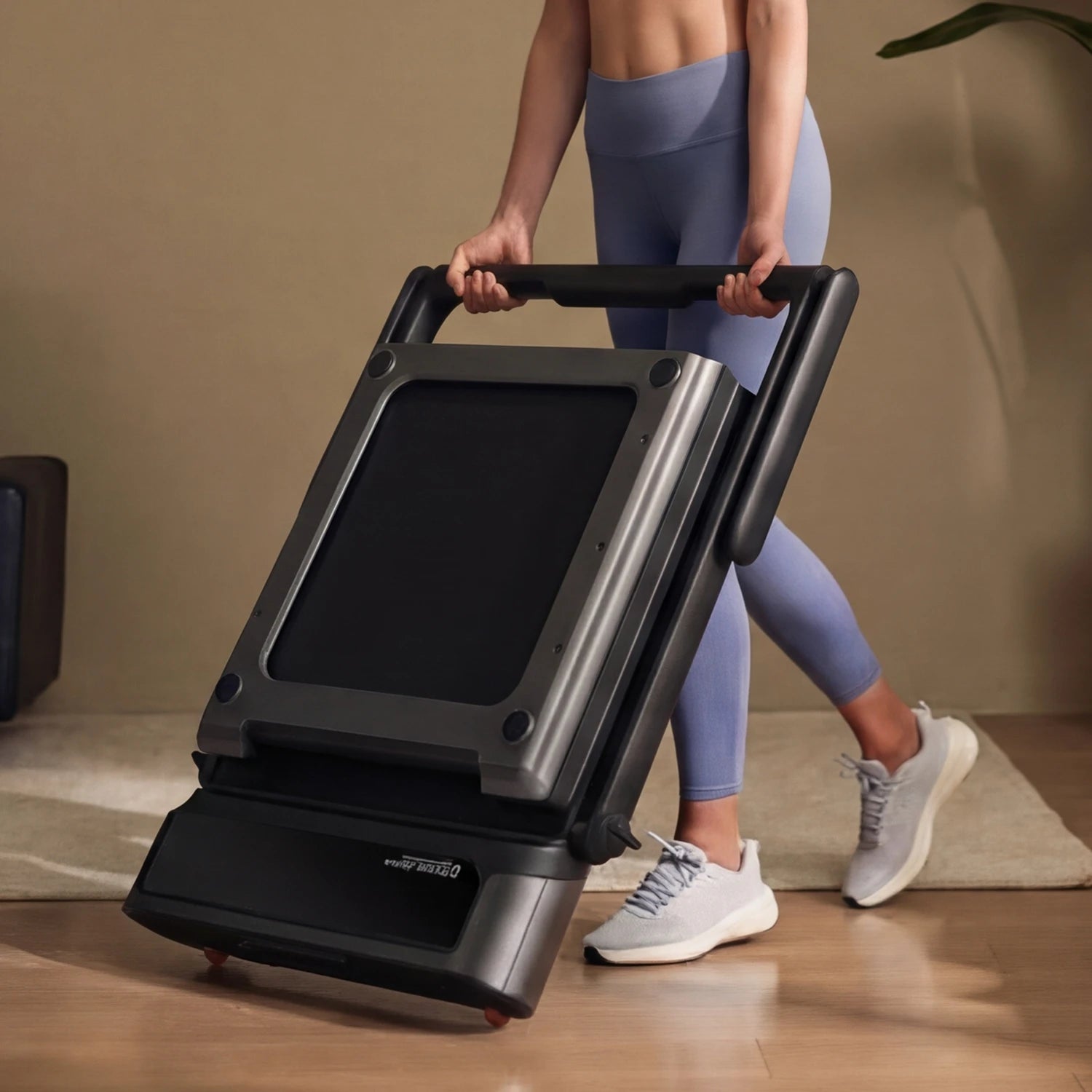 Woman folding WalkingPad R3 Hybrid plus treadmill for compact storage in a living room