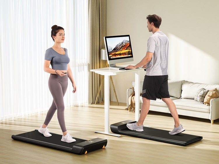 Man and woman using WalkingPad A1 Pro walking pads at home