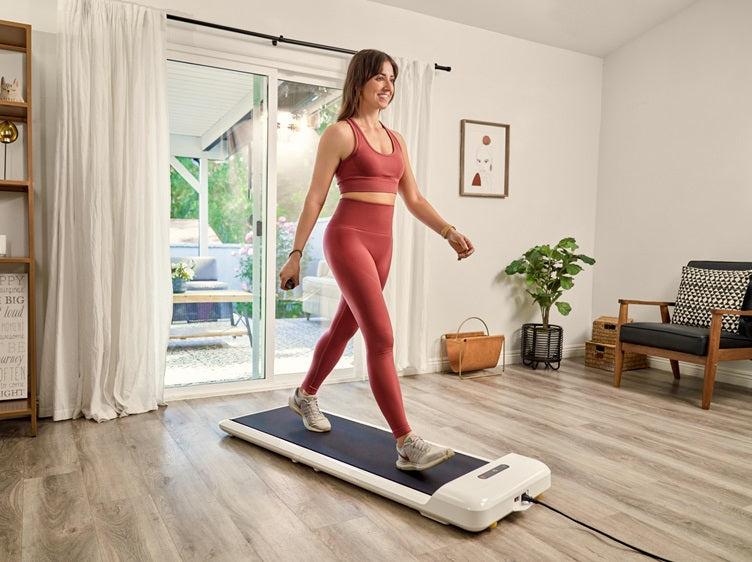 Woman walking on the WalkingPad C2 walking pad in a bright modern living room