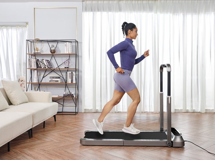 Woman jogging on a compact folding treadmill in a bright modern living room with natural window light