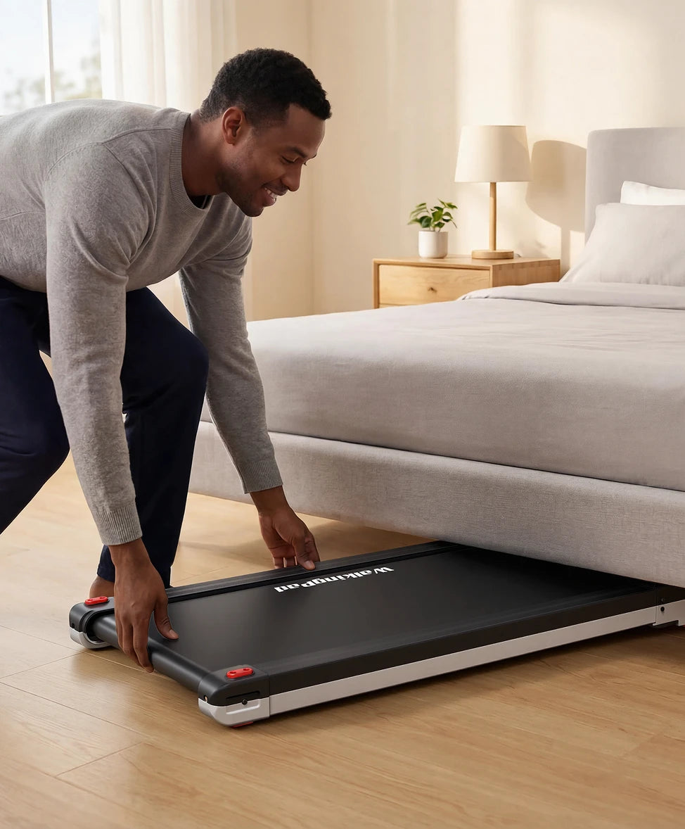 Man setting up a treadmill in a bedroom.