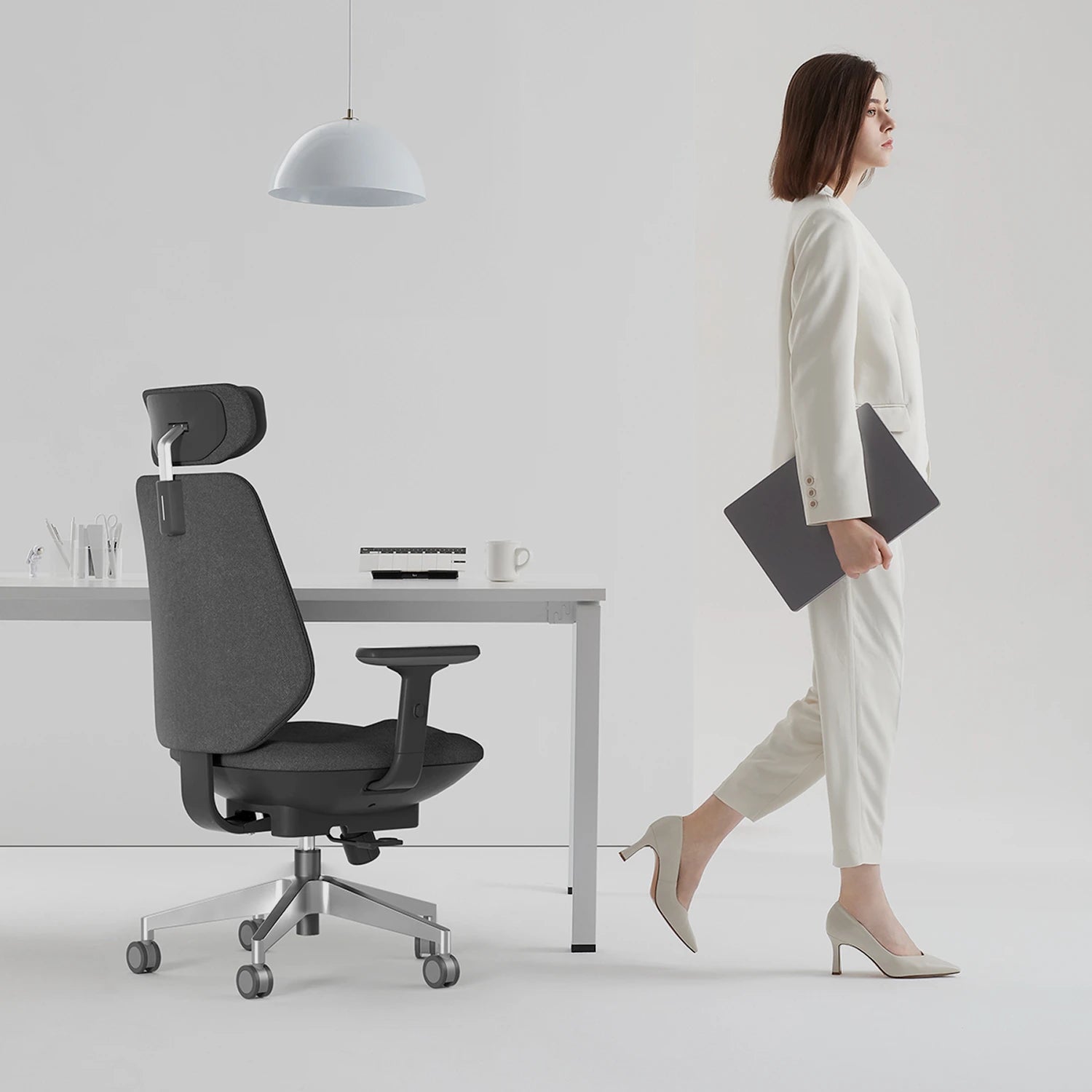 [scene] Woman using Air-Smart chair at standing desk in bright home office.