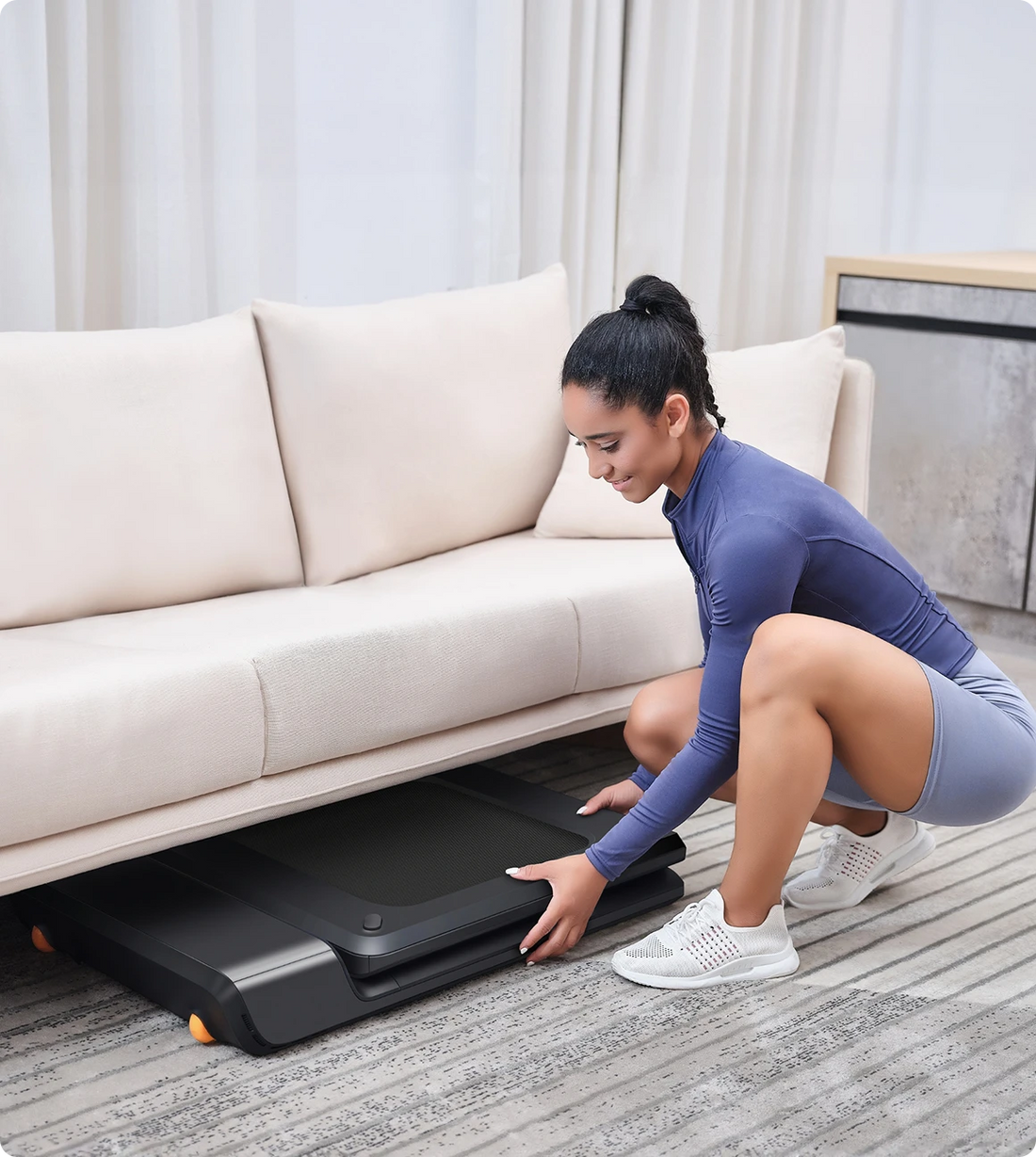 WalkingPad A1 Pro treadmill stored under sofa for space-saving home use