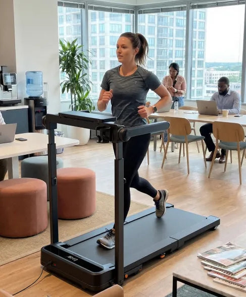 Woman running on the WalkingPad MX10 treadmill in a modern office workspace