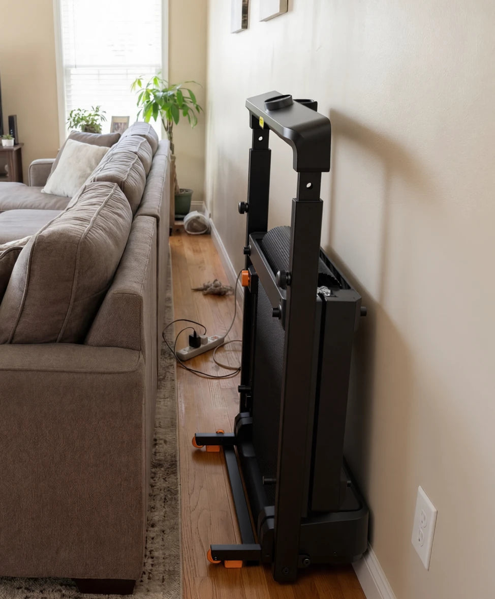 WalkingPad MX8 treadmill stored vertically beside a sofa to save space in a small living room