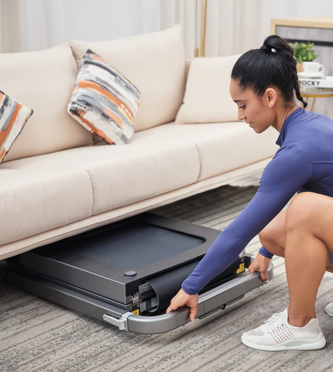 WalkingPad R2 treadmill stored under a sofa to save space in small homes