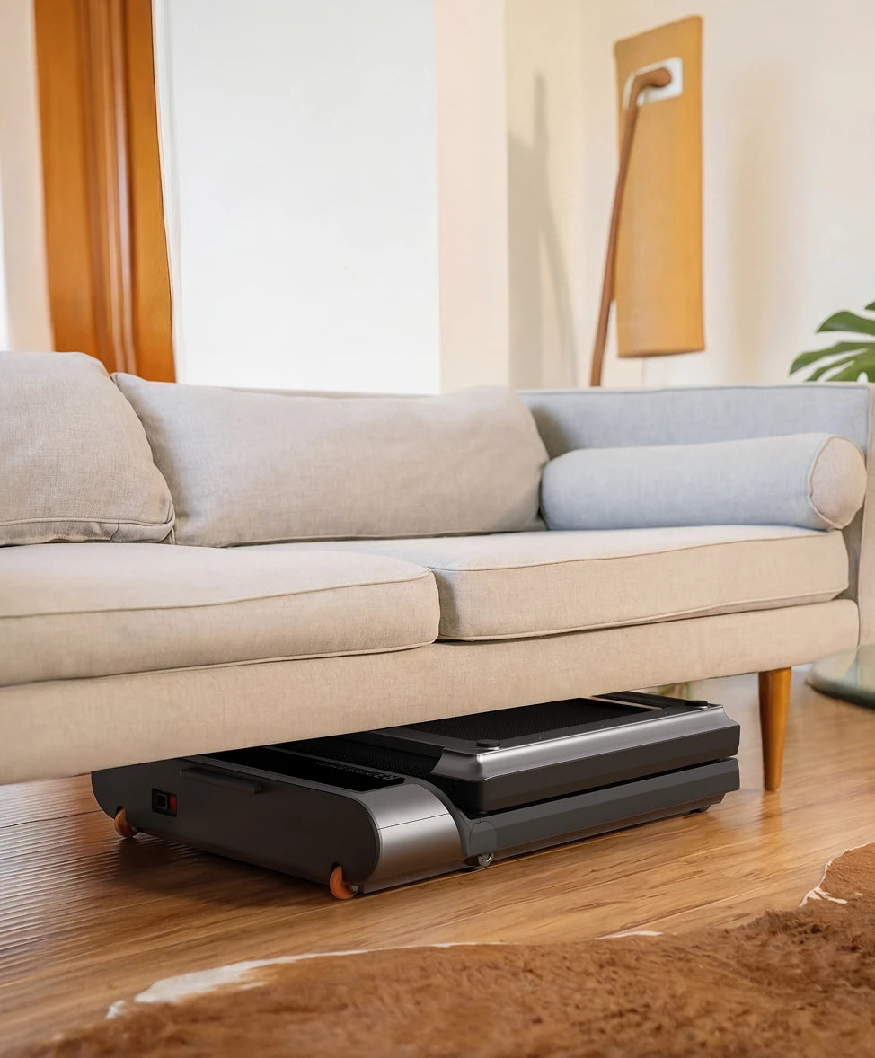 WalkingPad R3 treadmill folded and stored under sofa for space saving in living room