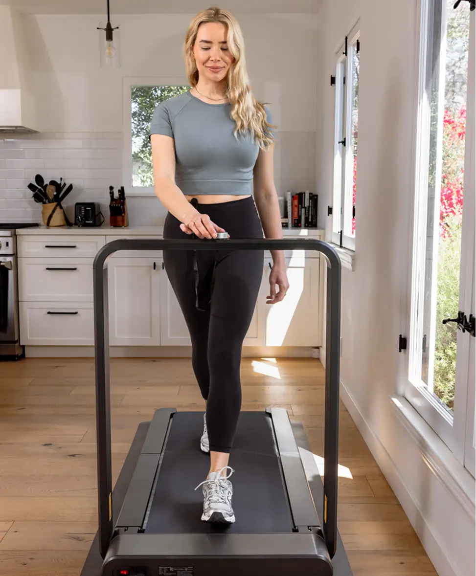 Woman walking on the WalkingPad X21 foldable treadmill during an indoor workout