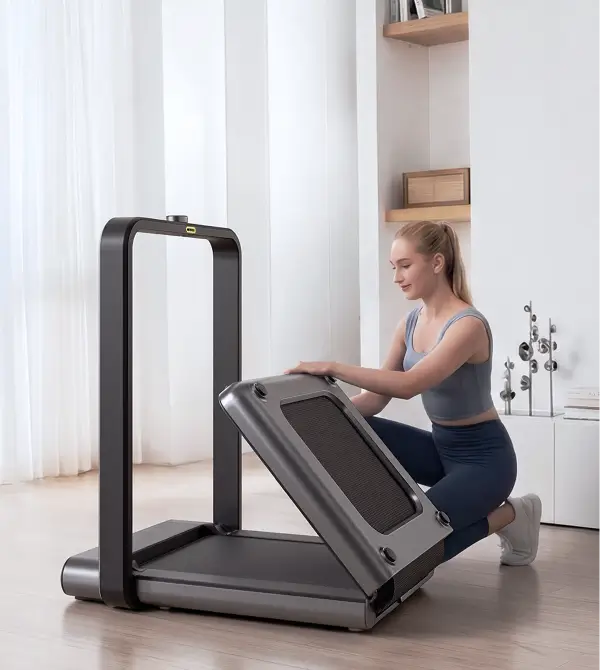 Woman folding the WalkingPad X21 treadmill for compact storage at home
